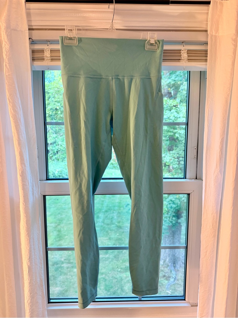 Lululemon light teal Leggings with side pockets and logo on back of calf